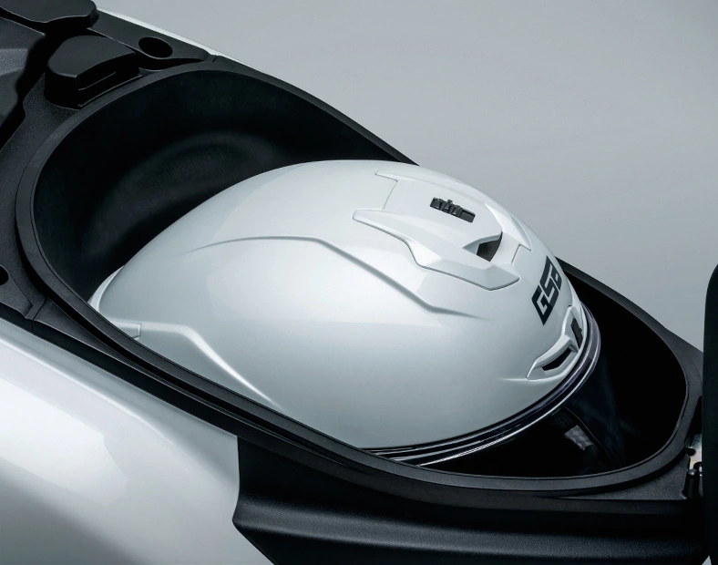 Capacete fechado branco guardado dentro do compartimento sob o banco da scooter Haojue Burgman ADX 125.