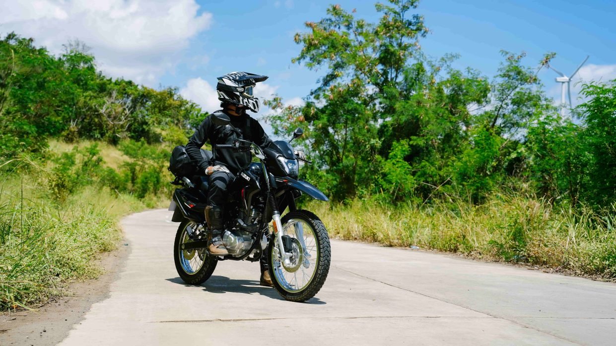 Piloto parado em cima de uma Haojue NK 160 preta
