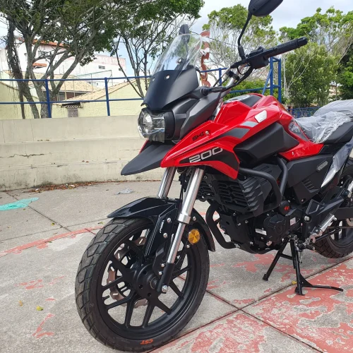 Moto Shineray Storm 200 EFI vermelha estacionada de lado na rua