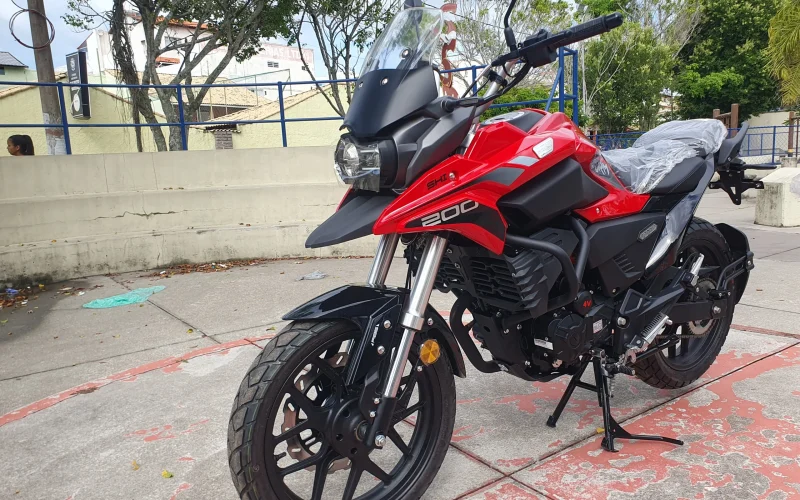 Moto Shineray Storm 200 EFI vermelha estacionada de lado na rua